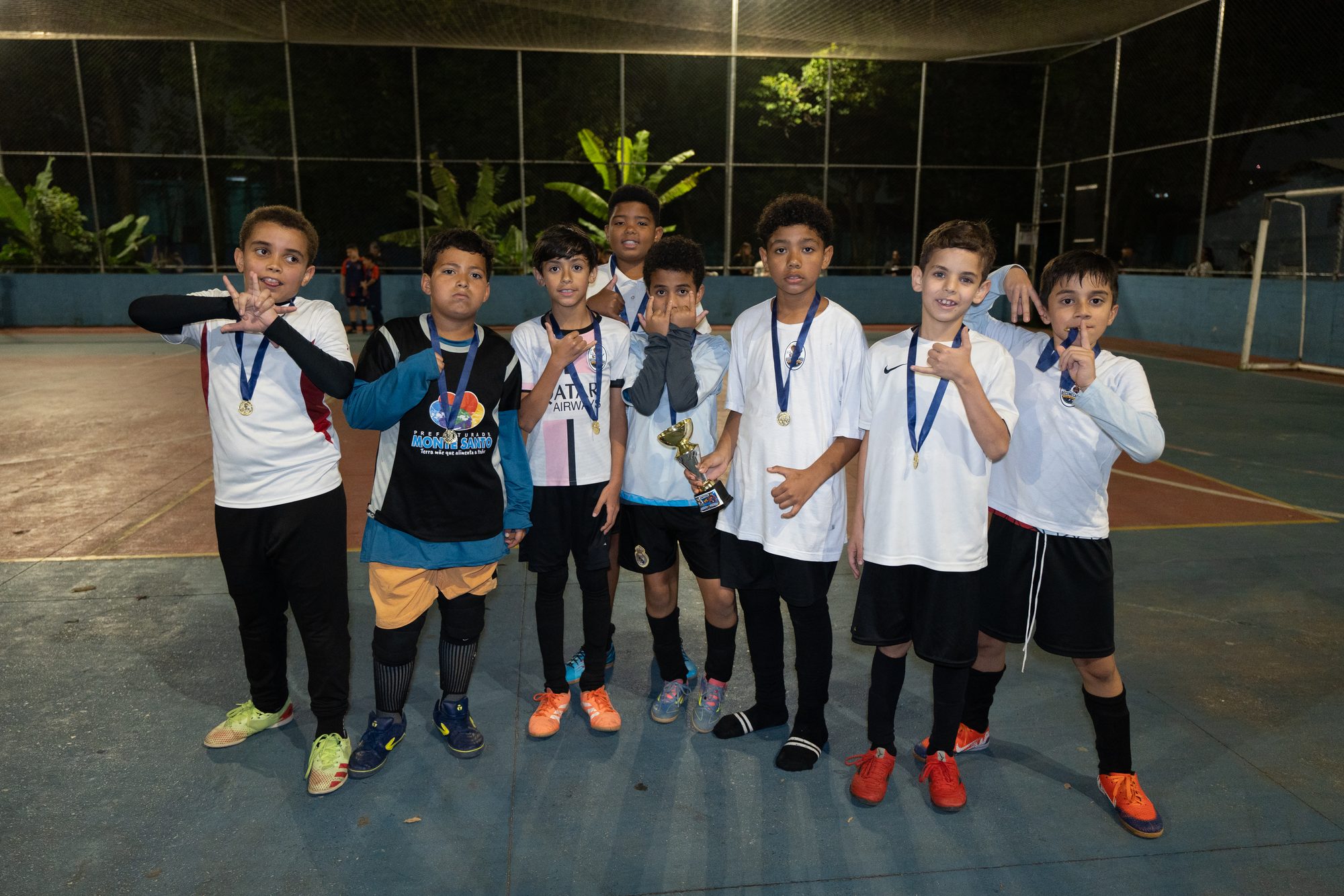 Time de uniforme branco com medalhas no peito